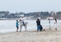 Photographer photographs as an instructor trains a young man to ride a horse on the Mediterranean coast near the city Ako in Israe