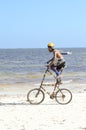 Acrobat with a double bike on the beach