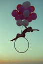 Acrobat hovers in the air on balloons. Royalty Free Stock Photo