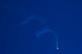 Acrobatic aeroplane with white spiral smoke trail on blue sky Royalty Free Stock Photo