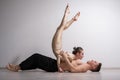 Acrobatic couple perform number on a white background. A duet of gymnasts rehearsing a performance with support. A man