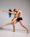 Acrobatic couple perform number on a white background. A duet of gymnasts rehearsing a performance with support. A man