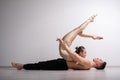 Acrobatic couple perform number on a white background. A duet of gymnasts rehearsing a performance with support. A man