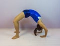 Acrobatic gymnastics the bridge a flexible back bend that requires a lot of power preformed by a young transgender girl in a blue