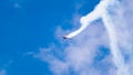 An acrobatic plane, flying in the blue sky with white clouds, doing acrobatics Royalty Free Stock Photo