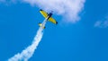 An acrobatic plane, flying in the blue sky with white clouds, doing acrobatics Royalty Free Stock Photo