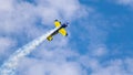 An acrobatic plane, flying in the blue sky with white clouds, doing acrobatics Royalty Free Stock Photo