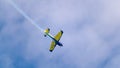 An acrobatic plane, flying in the blue sky with white clouds, doing acrobatics Royalty Free Stock Photo