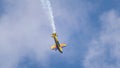 An acrobatic plane, flying in the blue sky with white clouds, doing acrobatics Royalty Free Stock Photo