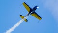 An acrobatic plane, flying in the blue sky with white clouds, doing acrobatics Royalty Free Stock Photo