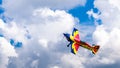 An acrobatic plane, flying in the blue sky with white clouds, doing acrobatics