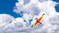 An acrobatic plane, flying in the blue sky with white clouds, doing acrobatics Royalty Free Stock Photo