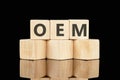 Acronym concept. OEM Original Equipment Manufacturer on wooden cubes on a black background