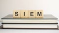 the acronym SIEM for Security information and event management concept represented by wooden letter tiles on a wooden table with