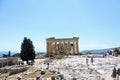 A large group of visitors admiring the Parthenon atop the Acropolis on a hot sunny day during a summer day in Athens