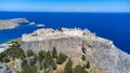 The Acropolis of Lindos in Rhodes island Greece. Saint Paul\'s Beach and Lindos Acropolis aerial panoramic view Royalty Free Stock Photo