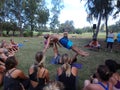 AcroYoga Teacher Jason Nemer balances instructor as class watches demonstration