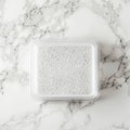 An acrylic food container with a bubbled lid rests on a marble work surface Royalty Free Stock Photo