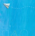 Paper airplane on a blue background with geometric shapes