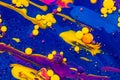 Acrylic paint balls abstract texture. Purple, blue and yellow liquids mix. Royalty Free Stock Photo