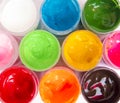 Acrylic paint in jars with covers open , top view, bright paint