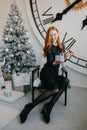 Act of Christmas gifts giving. Beautiful redhead young woman holding xmas gifts. Happy young woman opening Christmas