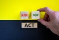 Act now or later. Businessman holds a cubes with word `now`. Wooden cubes with  words `act, later`. Beautiful yellow and black Royalty Free Stock Photo