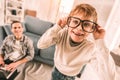 Little boy amusing himself by wearing his father`s reading glasses. Royalty Free Stock Photo