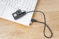 Action camera connected to a white laptop, against the background of a wooden table. Royalty Free Stock Photo