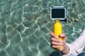 Action camera mockup in girls hand. Against the background of clear water in the pool