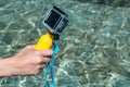 Action camera with a yellow float in the girl`s hand. against the backdrop of crystal clear water in the pool Royalty Free Stock Photo