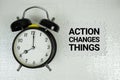 Action Changes Things text with alarm clock on white background Royalty Free Stock Photo