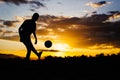 An action picture of a group of kids playing soccer football for exercise in community rural area under the sunset. Royalty Free Stock Photo