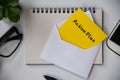Action Plan text on yellow note pad in an envelope with office concept background. Business concept Royalty Free Stock Photo