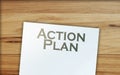 Action plan words, paper signs of dollar on wooden table. Business concept