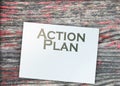 Action plan words, paper signs of dollar on wooden table. Business concept