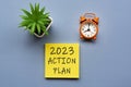 2023 action plan written on Adhesive Note and alarm clock set at 8 o'clock. Royalty Free Stock Photo