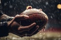 Action in the rain Football players hands grasp the wet ball