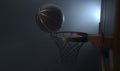 An action shot of a black and gold basketball teetering on the rim of a regular basketball hoop