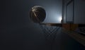 An action shot of a black and gold basketball teetering on the rim of a regular basketball hoop