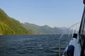 Action shot from the point of view of a person viewing from inside a boat, as it moves across the ocean with beautiful islands