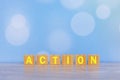 An action single word on wooden block with vintage soft blue bokeh background.. Business planning and strategy. Innovative ideas. Royalty Free Stock Photo