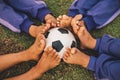 Action sport outdoors of a group of kids having fun playing soccer football for exercise in community rural area . Poor and povert