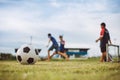 Action sport outdoors of kids having fun playing soccer football for exercise in community rural area under the twiligh