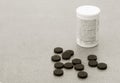 Activated Charcoal Tablets For cleansing the Body dumped On the Grey Background Royalty Free Stock Photo