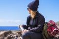 Active adult lady resting and taking a break while do trekking adventure activity inthe nature. Woman sit down on the rocks