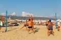 Active adults play the sport of volleyball on the sand beach