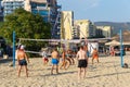 Active adults play the sport of volleyball on the sand beach