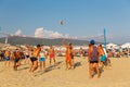 Active adults play the sport of volleyball on the sand beach