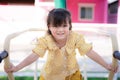 Active Asian child girl is climbing playing and exercising. Adorable girl is wearing a yellow-white checkered dress. Royalty Free Stock Photo
